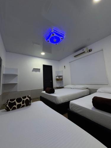 a room with three beds and a blue ceiling at Finca San José, Los Naranjos Santa Marta in Santa Marta