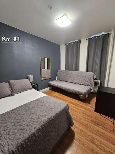 a bedroom with two beds and a blue wall at Shefah Hotel in Union City