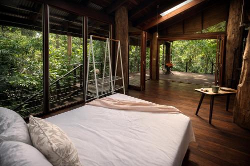 a bedroom with a bed in a room with windows at Firefly in Diwan