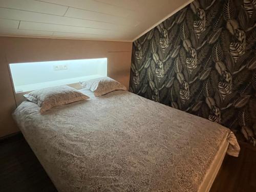 a bed with two pillows in a bedroom at Au Coin des Sources B&B Sart-lez-Spa in Sart-lez-Spa