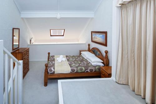 a bedroom with a bed and a window at Parkwood 6 - 2BR Split Lvl Apartment l Spa Bath l BBQ l Central Location in Jindabyne