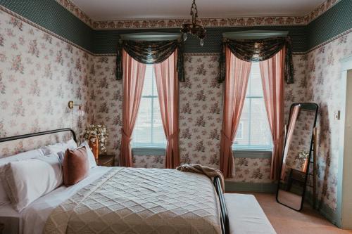 ein Schlafzimmer mit einem Bett und zwei Fenstern in der Unterkunft Strassner Suites - Opal in Hermann