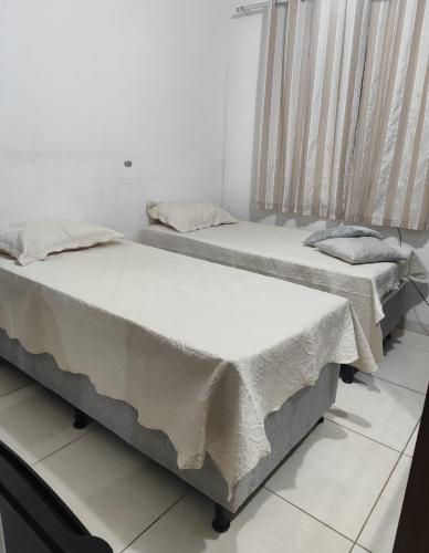 two beds sitting next to each other in a room at Casa da nicinha in Vitória