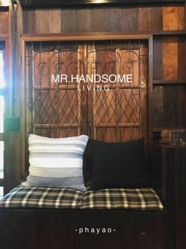 a bench with a sign that says mr kindnessphrine at mr handsome phayao in Ban Mae Ka Hua Thung