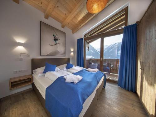 a bedroom with a bed and a large window at Alpine Chalet with Ski-In Access in Neukirchen am Großvenediger
