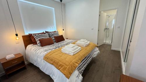 a bedroom with a bed with towels on it at AngraHouse in Angra do Heroísmo