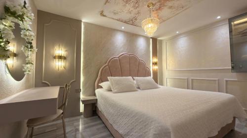a bedroom with a white bed and a desk at Hotel Paris Carré in Valledupar