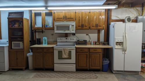 a kitchen with white appliances and wooden cabinets at Ouachita Campground at Edendell in Oden