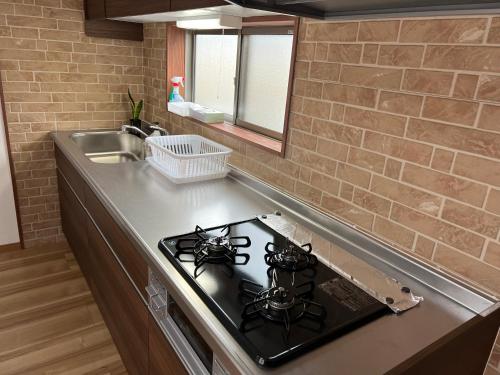 a kitchen with a stove and a counter top at ラフォーレハウス in Hitoyoshi