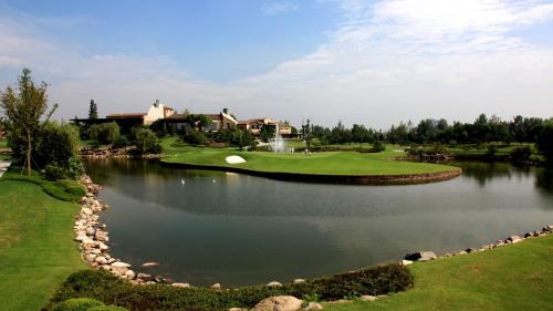 a golf course with a pond and a house at The Ritz-Carlton, Chengdu in Chengdu