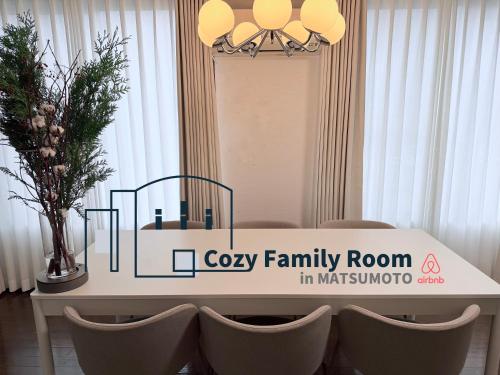a white table with a family room sign on it at Cozy Family Room 305 in Matsumoto