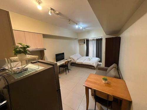 a small living room with a bed and a table at Ann's Haven in Cebu City