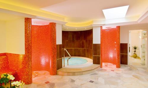 uma grande casa de banho com banheira de hidromassagem num edifício em Residence Villa Gran Baita em Selva di Val Gardena
