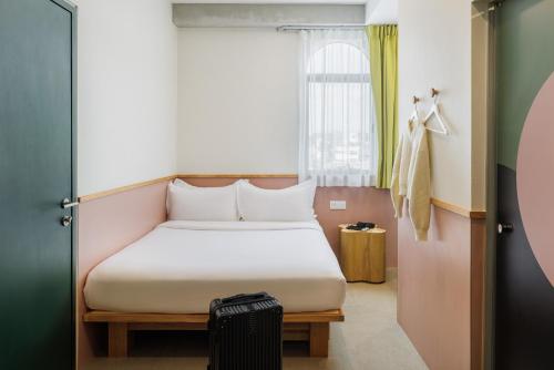 a small bedroom with a bed and a window at mu petite in Ipoh