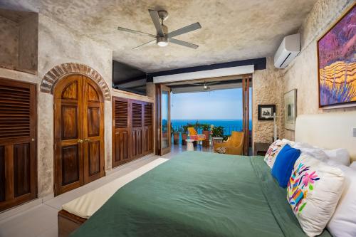 a bedroom with a bed and a view of the ocean at Charming condo featuring ocean views, pool & private terrace in Puerto Vallarta