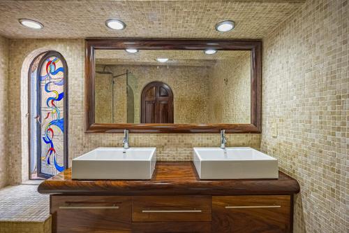 a bathroom with two sinks and a large mirror at Charming condo featuring ocean views, pool & private terrace in Puerto Vallarta