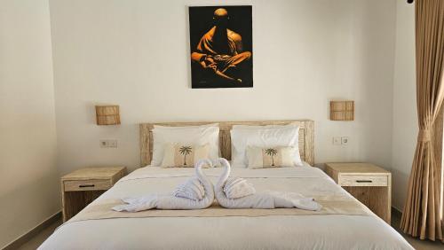a bedroom with a bed with two towels on it at Amed Saïta Villas in Amed