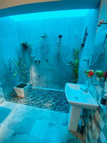a blue bathroom with a sink and a shower at Neo Grand Villa in Galle