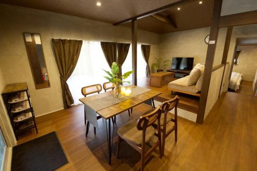 a living room with a table and chairs and a couch at Fukugi Beach Villa Okinawa in Nakijin