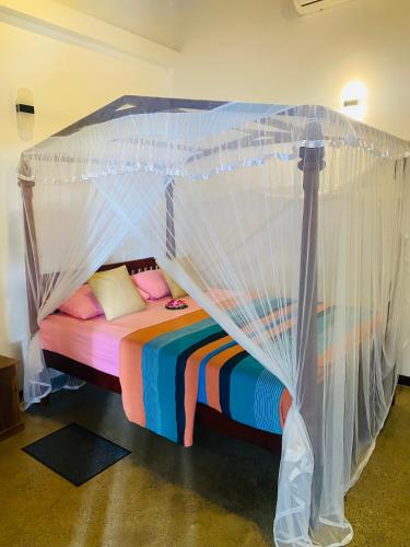 a bed with a canopy in a room at Neo Grand Villa in Galle