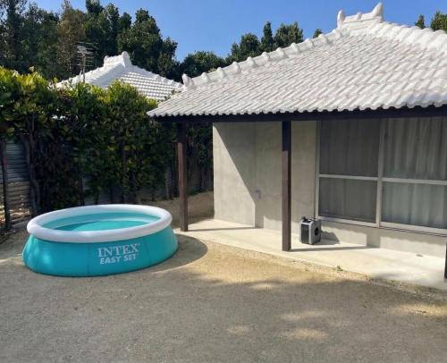 a house with a blue tub in front of a house at Fukugi Beach Villa Okinawa in Nakijin
