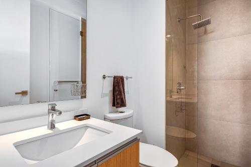 a bathroom with a sink and a toilet and a shower at Oceanfront condo with a full kitchen, pool, & beach access in Nuevo Vallarta