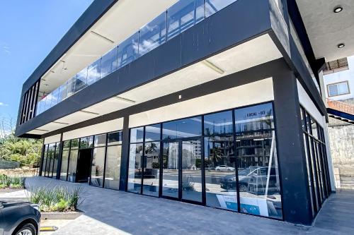 a building with large glass windows and a car in it at Ocean-view condo with infinity pool, rooftop lounge, & private balcony in Bucerías
