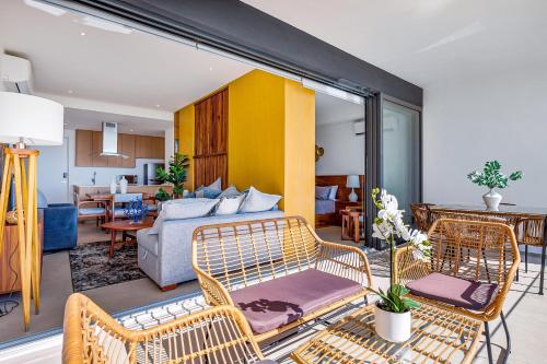 a living room with wicker chairs and a couch at Oceanfront condo with a full kitchen, pool, & beach access in Nuevo Vallarta
