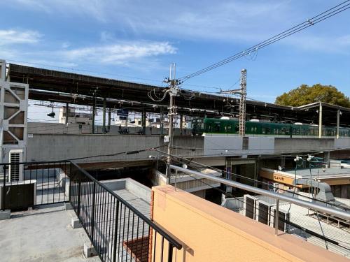 a train station with a train on a bridge at 京阪楽宿 in Kadoma