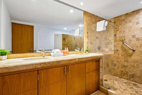 a bathroom with a sink and a shower at Stylish condo with covered balcony, pool & pool tables in Nuevo Vallarta