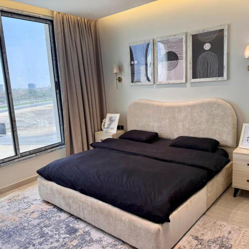 a bedroom with a large bed and a large window at Ocean Bliss Jacuzzi - Sea View- Check-in in Al Khobar