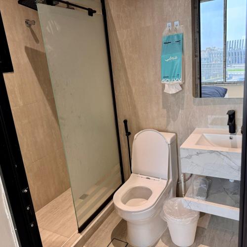 a bathroom with a toilet and a shower and a sink at Ocean Bliss Jacuzzi - Sea View- Check-in in Al Khobar