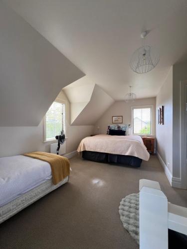 a attic bedroom with two beds and a staircase at Pinot Villas in Martinborough