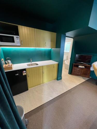 a kitchen with a sink and a blue wall at Pinot Villas in Martinborough