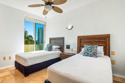 a bedroom with two beds and a ceiling fan at Ocean-view condo with private rooftop pool, terrace, & resort-style pool in Nuevo Vallarta