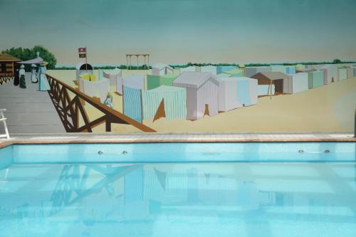 a swimming pool with a mural of a skate park at Hotel Abbazia in Grado