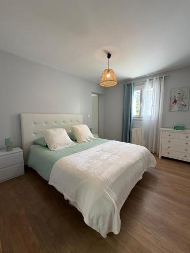 a bedroom with a large bed with a white blanket at Gite Matilon, 5 min Eugénie les Bains in Buanes