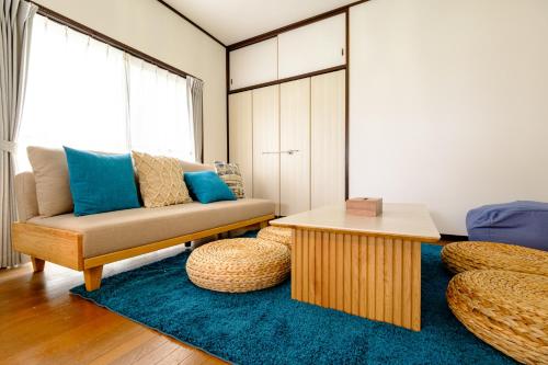 a living room with a couch and a table at 六鶴亭-ビーチ徒歩8分,スーパー徒歩2分,駅徒歩12分 in Manazuru