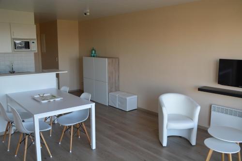 a living room with a white table and chairs at Apartment Green Garden Block L in Middelkerke