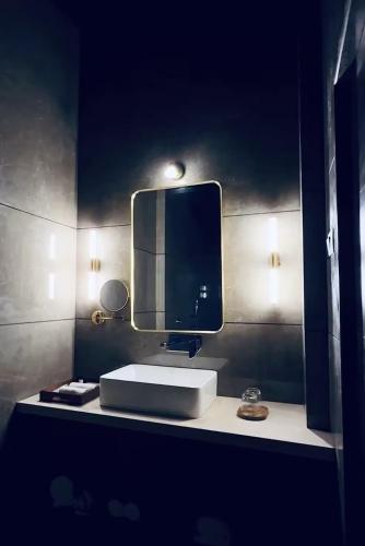 a bathroom with a sink and a mirror at The S - Luxurious Stays in Mahabaleshwar