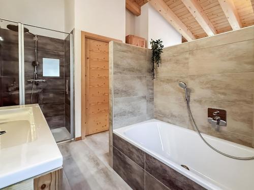 a bathroom with a tub and a shower and a sink at Elevate in Ovronnaz