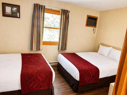 a hotel room with two beds and a window at Motel 6 Lake George, NY Adirondacks in Lake George
