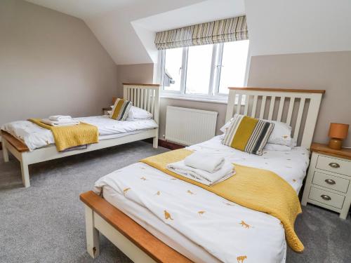 a bedroom with two beds and a window at Manor Wood in Coddington