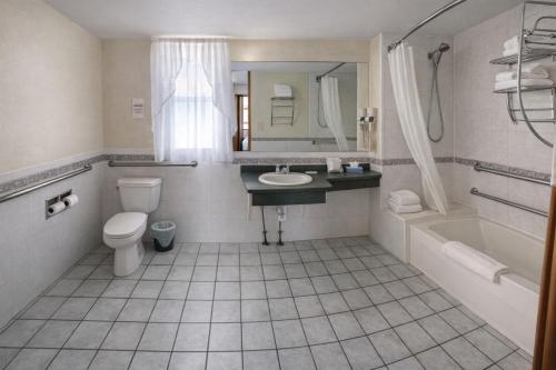 a bathroom with a sink and a toilet and a tub at Motel 6 Lake George, NY Adirondacks in Lake George
