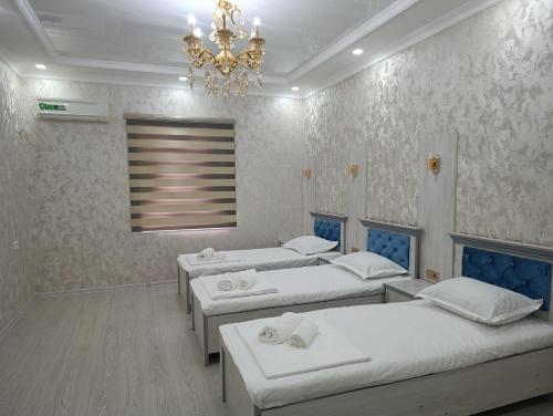 a room with four beds and a chandelier at COMFORT house in Khiva