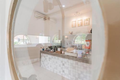 a white kitchen with a counter and a window at RedDoorz near Exit Toll Tanah Baru Bogor in Bogor