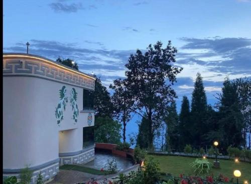 a building with a view of a garden and trees at The Cup House in Namchi