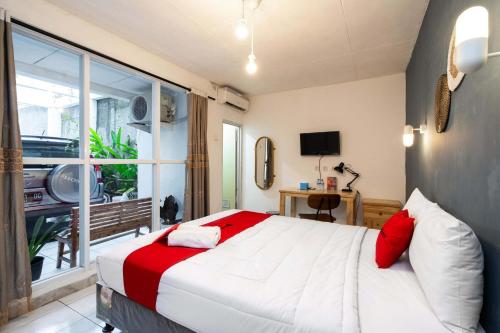 a bedroom with a large bed and a large window at RedDoorz near Exit Toll Tanah Baru Bogor in Bogor