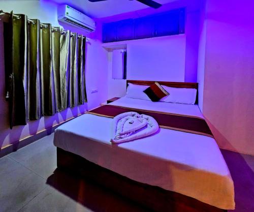 two beds in a room with purple lights at Cascade View in Cochin