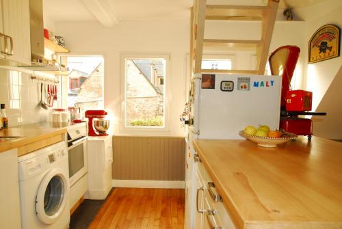 - une cuisine équipée d'un réfrigérateur et d'une corbeille de fruits sur un comptoir dans l'établissement Saint-Malo Apartment, à Saint-Malo